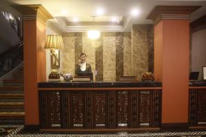 a woman sitting at a desk in a hotel lobby at Herald Suites Polaris in Manila