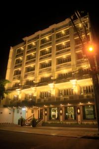 a large white building with lights on it at night at Herald Suites Polaris in Manila