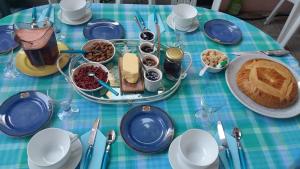 a blue and green table topped with food and desserts at Les Hibiscus in Saint-Jean-le-Centenier
