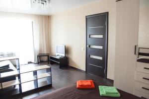 トムスクにあるАпартаменты Учебная 7のリビングルーム(ベッド1台、テレビ付)