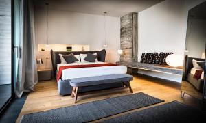a bedroom with a bed and a bench in it at Teku Sardinia Boutique Hotel in Bari Sardo