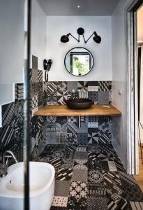 a bathroom with black and white tiles and a sink at Teku Sardinia Boutique Hotel in Bari Sardo