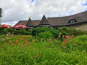 a house with a field of flowers in front of it at Landhotel Hubertus in Unterelsbach