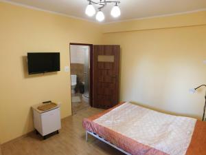 a bedroom with a bed and a flat screen tv at Pokoje goscinne Marcin in Łeba +55 photos