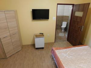 a bedroom with a toilet and a television on the wall at Pokoje goscinne Marcin in Łeba