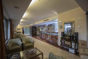 a living room with couches and a bar at La Fonte Hotel in Ome