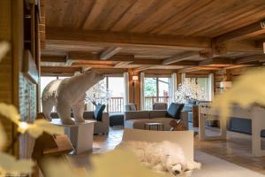 une statue d'ours polaire dans un salon avec un chien dans l'établissement Les Chalets Du Gypse, à Saint-Martin-de-Belleville