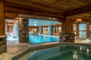 a swimming pool in a house with a large room at Les Chalets Du Gypse in Saint-Martin-de-Belleville