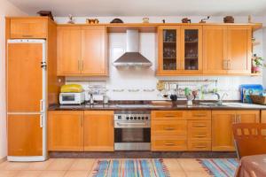 a kitchen with wooden cabinets and a stove top oven at Casa Nea in El Rosario