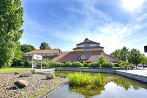 a building with a pond in front of a building at Parkhotel Stader Hof in Stade