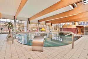 a large indoor pool in a building with windows at Sporthotel Kapfenberg in Kapfenberg
