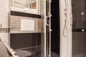 szklane drzwi prysznicowe z półką z ręcznikami w obiekcie Apartment Nearto Old Town Na Ustroniu street w Krakowie
