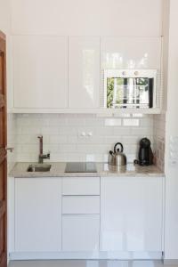 a white kitchen with white cabinets and a sink at Apartment Nearto Old Town Na Ustroniu street in Krakow