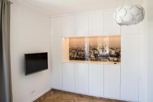 a living room with a television and a white wall at Apartment Nearto Old Town Na Ustroniu street in Krakow