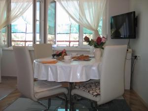 mesa de comedor con mantel y sillas blancas en Apartment Kovacic Jurlina, en Poljica