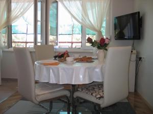 a dining room table with a white table cloth and chairs at Apartment Kovacic Jurlina in Poljica
