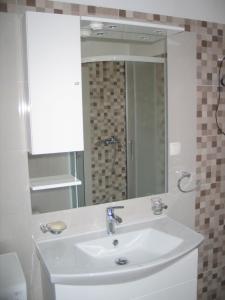 a bathroom with a sink and a mirror at Apartment Kovacic Jurlina in Poljica +18 photos