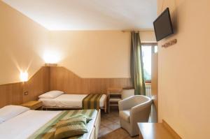 a hotel room with two beds and a television at Hotel Da Giovanna in Chiusi della Verna
