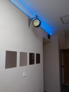 a clock hanging from a wall with a blue ceiling at Green Panda Apartments in Budapest