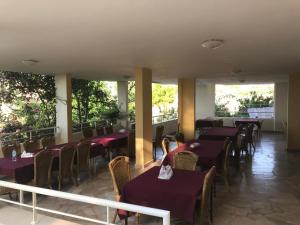 a restaurant with purple tables and chairs and windows at Luna Motel in Naqoura