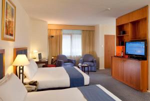 a hotel room with a television and a bed at Seasons Of Perth in Perth