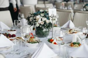 een tafel met borden en een vaas met bloemen bij Castello Mare Hotel in Kobuleti