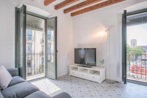 sala de estar con TV y 2 ventanas grandes en Flateli Rambla 5 3-2, en Girona