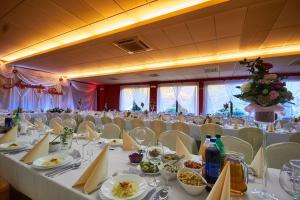 duża sala bankietowa z białymi stołami i krzesłami w obiekcie Hotel Paola w Kutnie