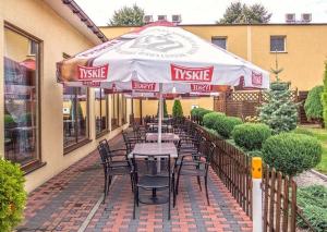 stół i krzesła pod parasolem na patio w obiekcie Hotel Paola w Kutnie