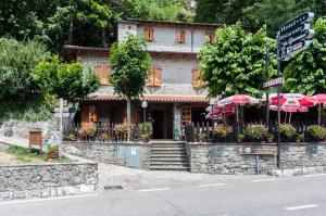 a building with umbrellas on the side of a street at Hotel Da Giovanna in Chiusi della Verna