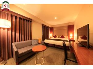 a hotel room with a bed and a couch at Richmond Hotel Tokyo Shiba in Tokyo