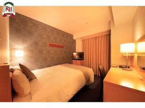 a hotel room with two beds and a desk at Richmond Hotel Tokyo Shiba in Tokyo