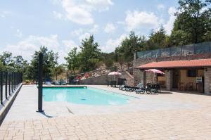 a swimming pool in a courtyard with a building at Hotel Da Giovanna in Chiusi della Verna
