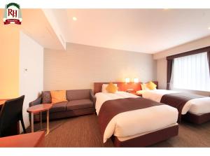 a hotel room with two beds and a couch at Richmond Hotel Tokyo Shiba in Tokyo
