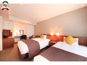 a hotel room with two beds and a television at Richmond Hotel Tokyo Shiba in Tokyo