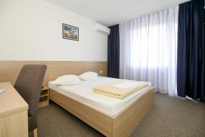 una camera con letto, scrivania e finestra di Hotel Zagreb a Spalato (Split)