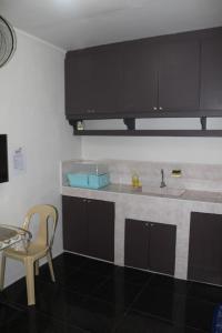 a kitchen with black cabinets and a table and a chair at RV Transient in Angeles