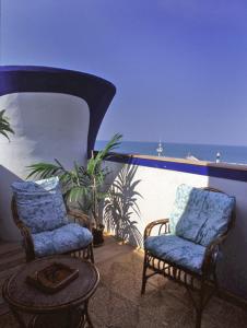 two chairs and a table on a balcony with the ocean at Residence Darsena in Cattolica