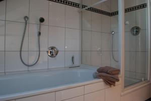 ein Badezimmer mit Badewanne und Glasdusche in der Unterkunft Ferienwohnung Wolf in Greven + 13 Fotos