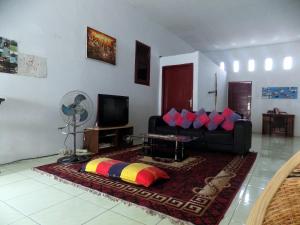Una sala de estar con un sofá y un televisor. en Amelia 2 Guest House Syariah, en Medan 17 fotos más
