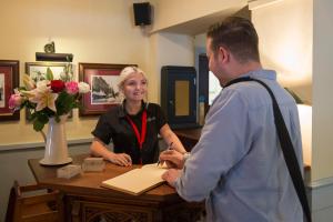 a man and a woman shaking hands at a table at Green Dragon, Welton by Marston's Inns in South Cave