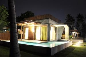 een klein huis met een zwembad in de nacht bij Coconutnoom Ko Phangan in Thongsala