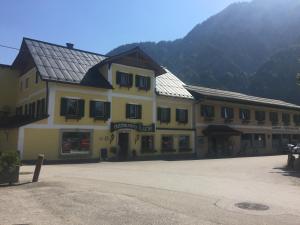 a large yellow building with a mountain in the background at Metzgerwirt Vieh Heli in Bad Goisern