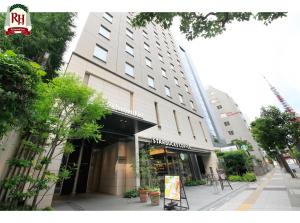 a tall building with a store on a city street at Richmond Hotel Tokyo Shiba in Tokyo