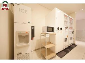 a white room with a microwave on a shelf at Richmond Hotel Tokyo Shiba in Tokyo