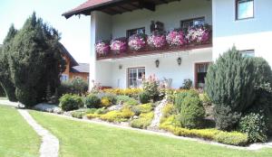 a garden in front of a building with flowers at Pension Waldhof in Koppl
