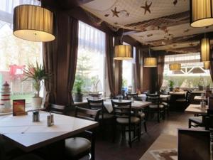 ein Esszimmer mit Tischen und Stühlen und Fenstern in der Unterkunft Weinhaus Hotel in Norddeich