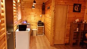 a kitchen with wooden walls and a refrigerator at Asbn Magic Garden in Acre