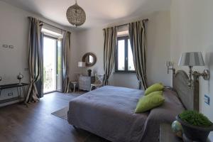 a bedroom with a bed with green pillows on it at Casale Virginia in Cesariano