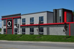un bâtiment avec une bande rouge sur son côté dans l'établissement Hôtel Ô Laval, à Laval